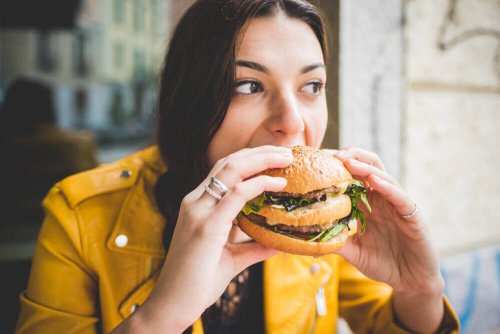 A woman eating a hamburger.