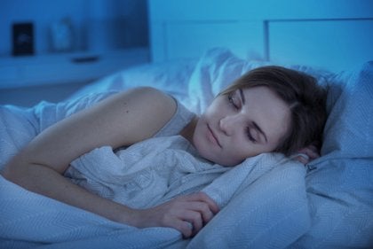 A woman practicing good sleep hygiene.