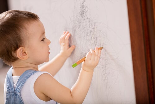 A boy drawing on a piece of paper.