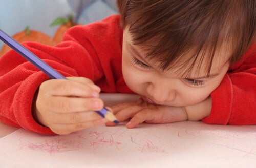 A child scribbling with a colored pencil.