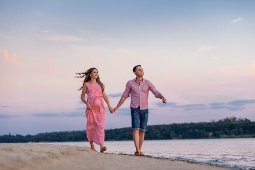 A couple walking together on a beach.