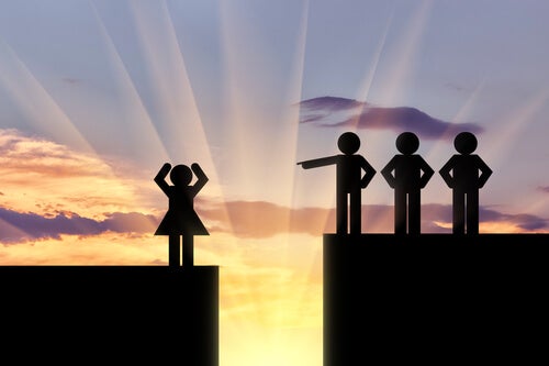Three male figurines standing on a platform above a woman, pointing at her.