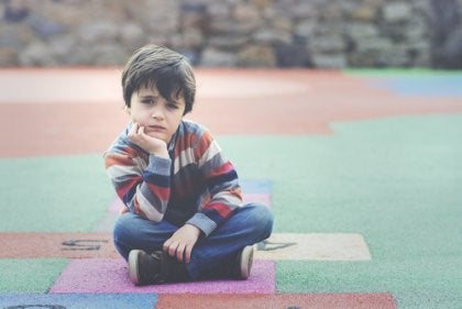 A pensive child sitting cross-legged.