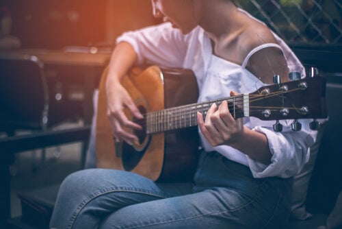 A woman playing a guitar to grow new neurons. 