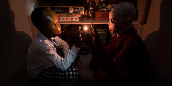 Children sitting beside each other with masks on.