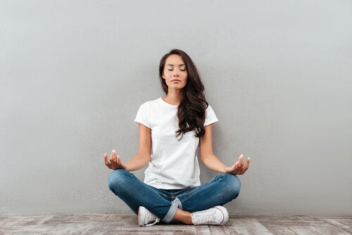 A woman meditating on the floor.