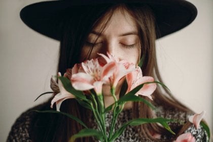 A woman smelling flowers.
