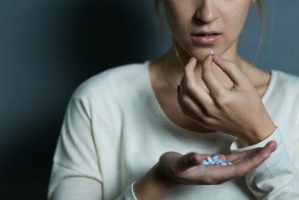 A woman taking a pill.