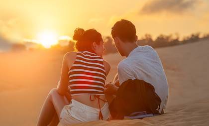 A couple sitting together on a beach.
