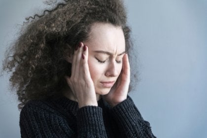 A curly-haired woman with a headache.