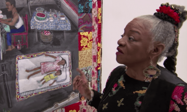 Faith Ringgold looking at some artwork.