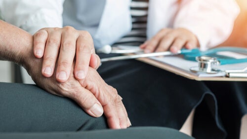 A doctor placing their hand on top of a patient's.