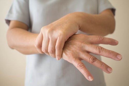 A patient with their hand squeezing their wrist, in pain.
