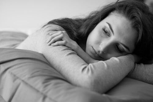 A sad girl lying in her bed.