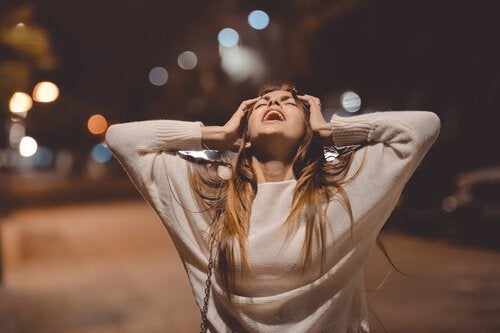 A woman in the anger stage of grief yelling in the street.