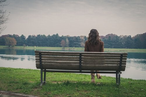 A woman sitting alone on a bench.