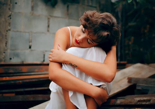 A woman hugging a pillow.