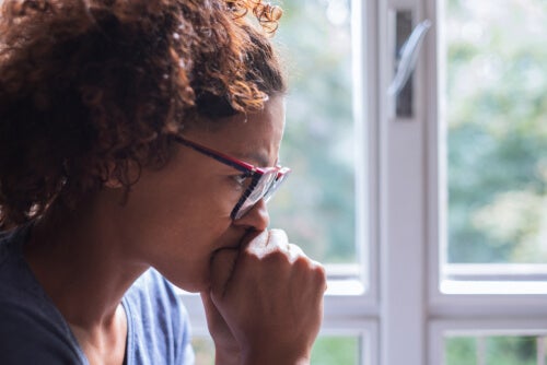 A concerned woman by a window.