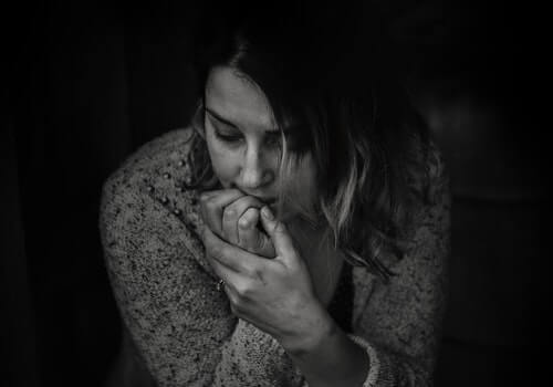 A woman biting on her nails.
