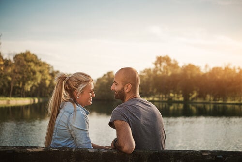 A man and a woman talking at the lake.