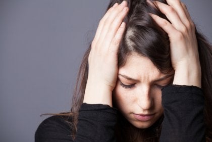 A stressed woman with her hands on her head.