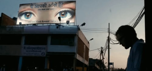 A man standing in the street at night in a scene of I Origins.