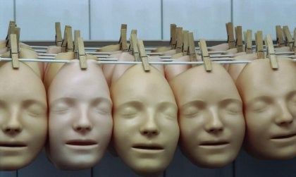 Realistic face masks hanging from a clothesline.