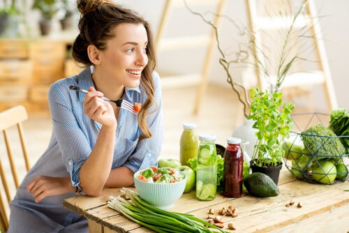 A woman eating a salad at a table.