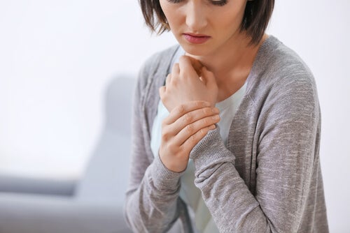 A woman rubbing her wrist.
