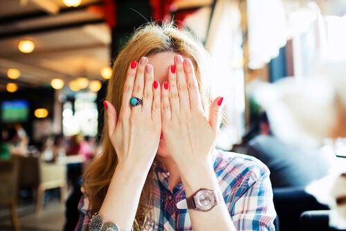 A woman covering her face.