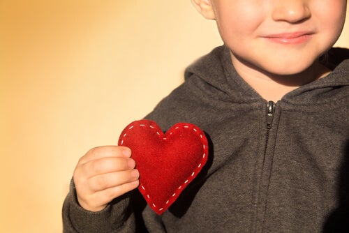 A little boy holding a heart.