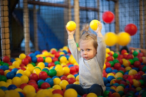 A child playing in a ballpit.