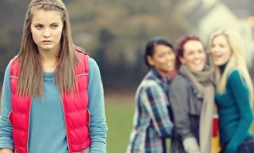 A group of young women laughing at another.