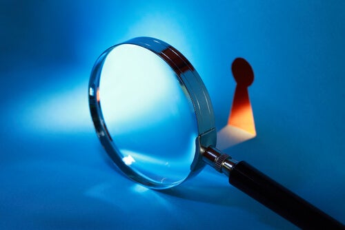 A magnifying glass pointing at a keyhole.