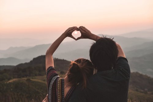 A couple making a heart with their hands, sharing the value of love.