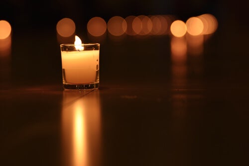 A small lit candle in the dark.