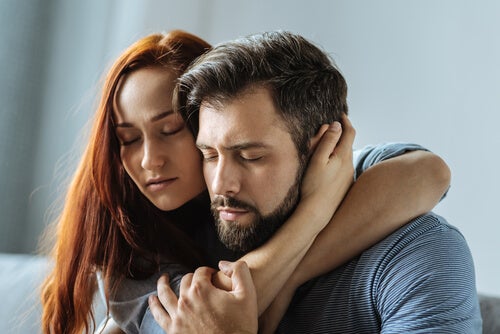 A couple hugging with their eyes closed.