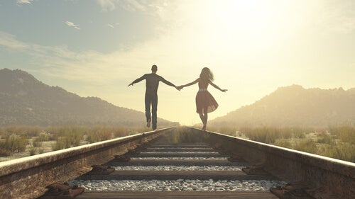 A couple dancing near a train track.