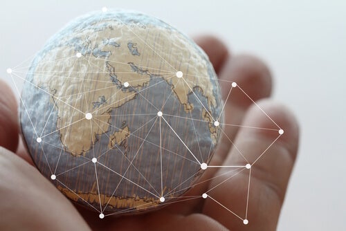 A hand holding a model of the earth.