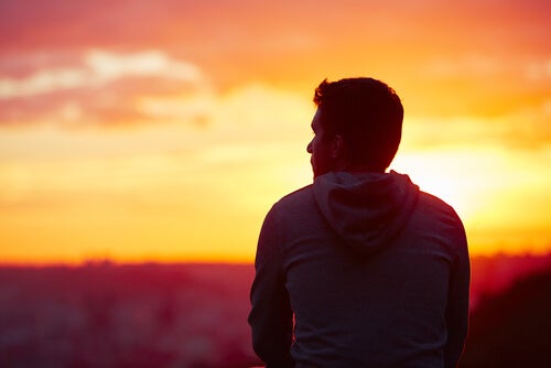 A man watching the sunset by himself.