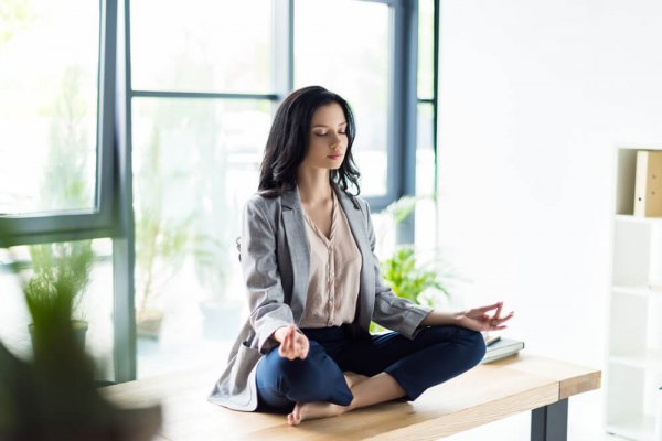 A woman meditating at home.