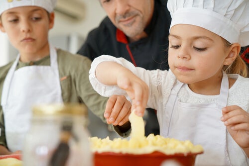 A girl and a boy cooking with their father.