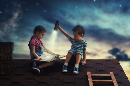 Two kids reading on a roof.