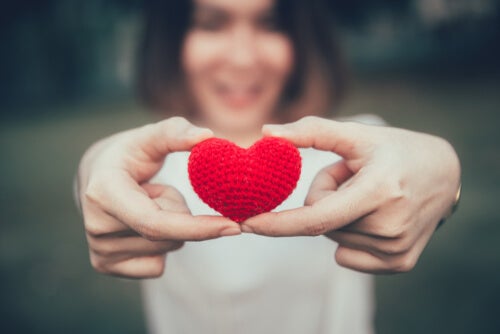 A woman holding a red heart.