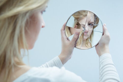 A woman looking at a shattered mirror symbolizing the glass delusion.