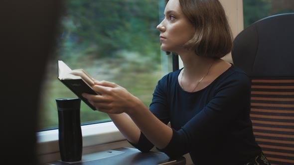 A woman reading on a train.