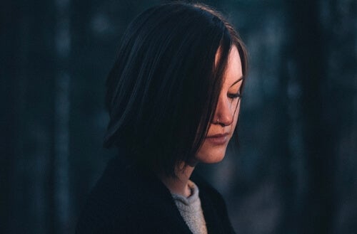 A woman with black hair looking sad.