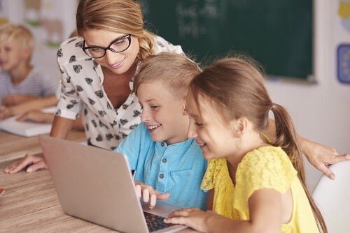 A woman looking over two children's shoulders.