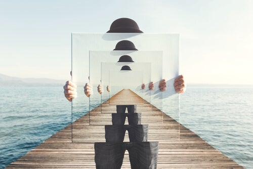 A man holding a mirror reflecting an image multiple times.
