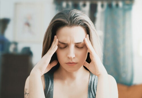A woman with her hands on her head thinking about ego-depletion theory.